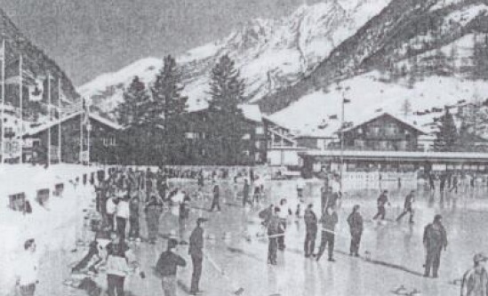 Ein Bild aus vergangenen Zeiten in Zermatt. Auf dem Bild ist ein Eisfeld zu sehen auf dem Leute Curling spielen.